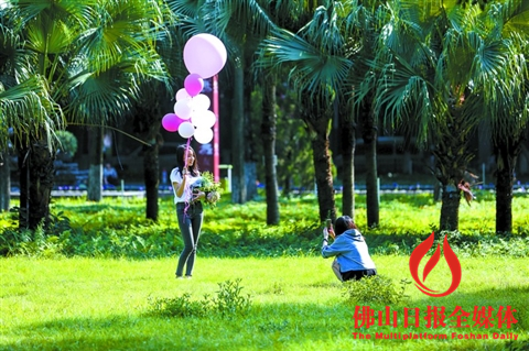昨日下午,天气晴朗,南海桂城千灯湖公园内,两名女孩在阳光下拍照。/佛山日报记者王伟楠摄