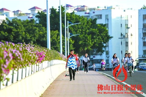 天气转凉,市民需及时添衣保暖。图为三水区沙头大桥,一名背着婴儿的市民用毛毯为婴儿保暖。/ 佛山日报记者陈浩森摄