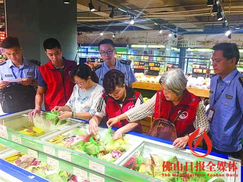 在“你点我抽”阳光抽检活动中,志愿者挑选粽子进行抽检。