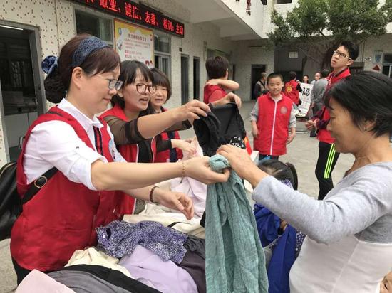 义工们向凤兰小学学生家长发放爱心物资。