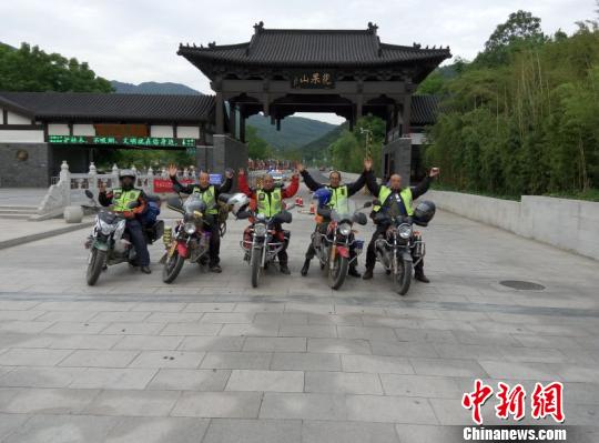 郝学生(左一)与“摩友”骑摩托车去江苏省南云台山中麓,在花果山景区门前合影留念。 受访人提供