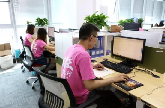 身穿粉红色团队服装的员工在各自的岗位上埋头苦干