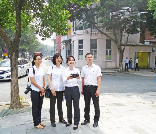 广州市南方公证处工作人员使用无人机对芳村酒吧风情一条街进行拍摄和录像，保全证据。