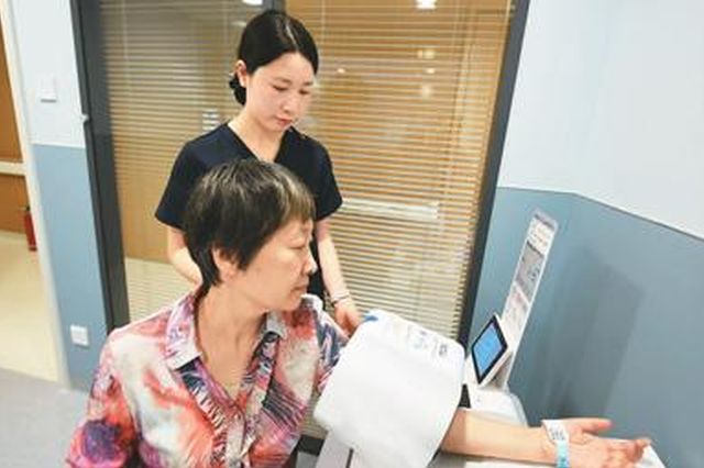 北京首家互联网医疗全科中心的医护人员在为市民测量血压和脉搏。龙巍 摄 (人民图片)