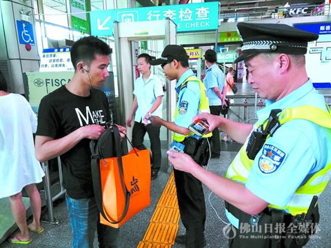 顺德警方在客运站进行日常巡查期间，民警向乘客核实身份信息。