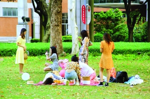 女孩子们穿着各色花裙子一边野餐一边拍照