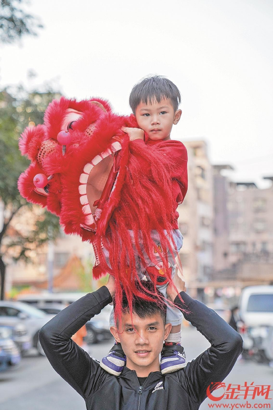 员村，罗定国和他的儿子罗晟玮。不到三岁的罗晟玮从小耳濡目染，如今舞起小狮头有模有样