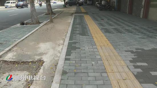 西荣路施工工人正加紧铺设人行步道砖