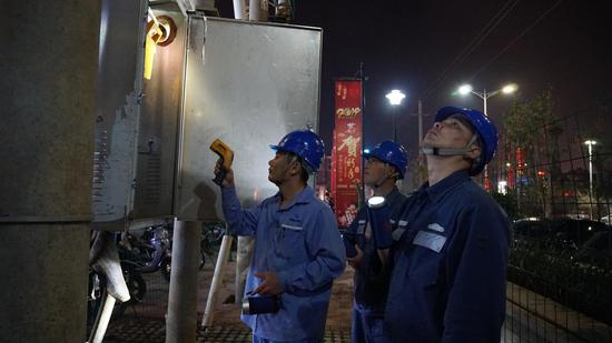 　　为保障群众亮堂过新年，徐闻供电局提前部署，配齐396名保供电人员和充足物资，保障了徐闻电网的安全稳定运行，完成春节保供电任务。图为除夕夜保供电人员对商场、住宅小区等人口密集场所供电线路设备进行巡视测温。翁红玲 摄