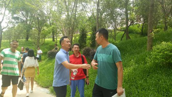 （收房日当天，6栋的业主代表任先生[蓝色衣服]在为大家解疑答惑）