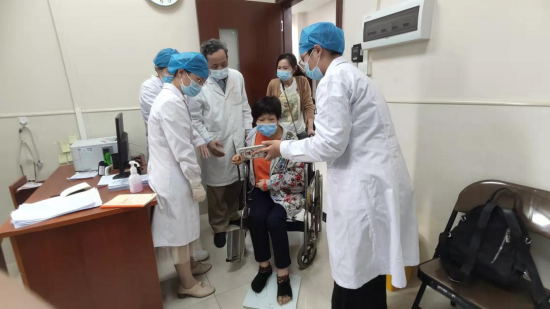 陈卓铭与医护人员指导求诊群众用平衡板锻炼