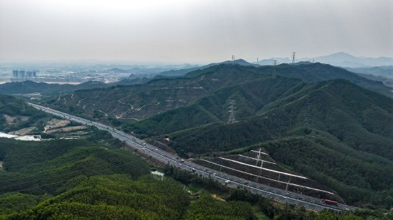 换上新装的500千伏五江甲乙线跨越高速公路、高山河谷，将奔涌的绿色电能输送至粤港澳大湾区。