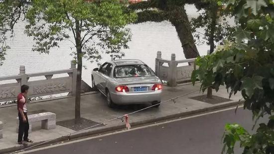 5月24日中午  一辆小轿车将石护栏撞倒  险些冲入湖中