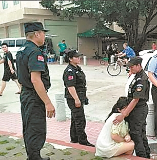 ▶在等待民警到场期间，女子坐在路边台阶，依靠在女队员身上埋头哭泣。