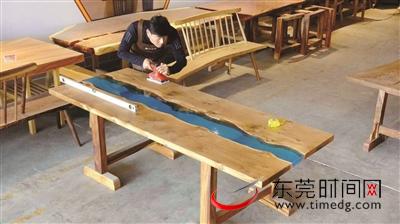 陈建明将亚克力材料与木料融为一体，做成拼接图案的桌子 受访者供图