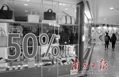 今年2月,香港铜锣湾一家店铺减价促销,顾客从附近经过。新华社发