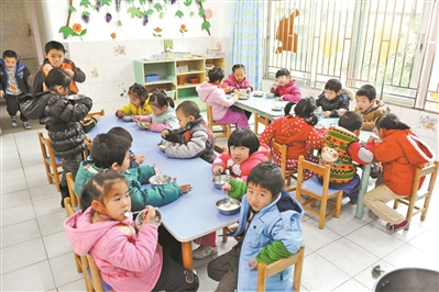 在幼儿园中吃饭的孩子。