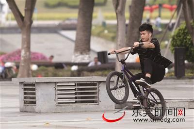 市中心广场，一位年轻人在玩极限单车 （记者 陈栋 摄）