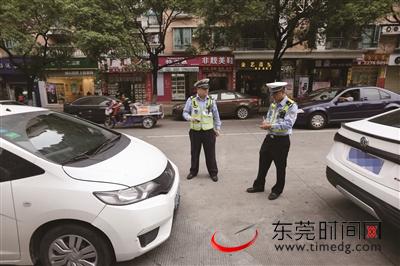 ▲昨日，莞城雍华庭东平街，交警正在对违停车辆进行查处 （记者 陈帆 摄）