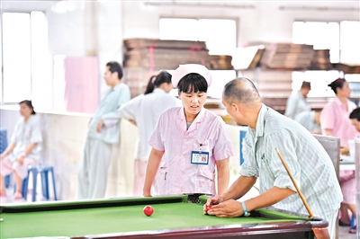 护士和打台球的病人在交流。