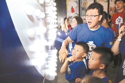 几位小朋友在观看活动现场的展品。