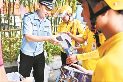 民警将宣传单交给外卖小哥。