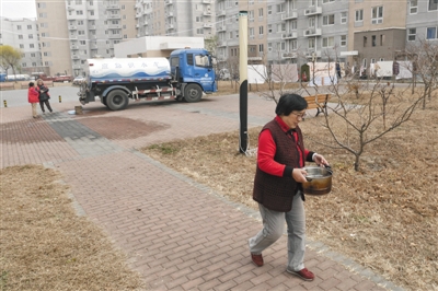 昨日,北京市海淀区馨瑞嘉园小区,居民从自来水集团的应急供水车取水。记者 王嘉宁
