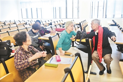 老同学在教室里叙旧,追忆当年同学时光。