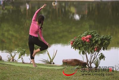 东莞植物园，女子在湖畔练瑜伽 （记者 陈栋 摄）