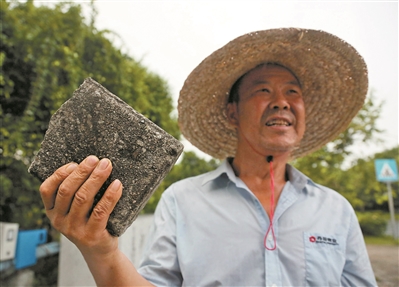 彭元青举起那块“救命砖头”讲述救人的情景。