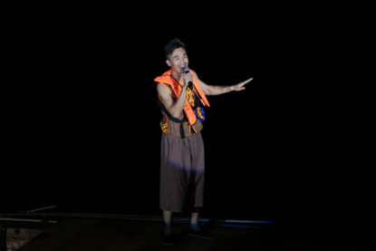 “汀见顺德 渔舟唱晚音乐夜”上,在江中,男歌手站在渔舟上唱响咸水歌