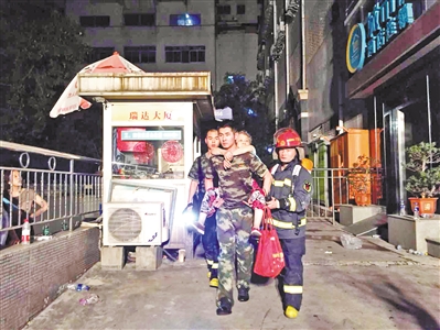 左图：消防员背着一名老人走出火灾现场。广州日报全媒体记者邱伟荣 摄