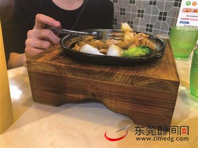 记者点了一份榨菜肉丝啫啫肠，发现餐具的缝隙里钻出两只小黑虫（红圈处），记者把情况反映给店家之后，店家做了退单处理 （记者 李梦颖 摄）