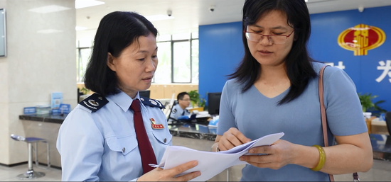 仲恺区税务局办税大厅负责人张凤英（左）。