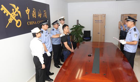 7月27日晚,办案人员对嫌疑人王某宣读逮捕证。(赵立阳 摄影)