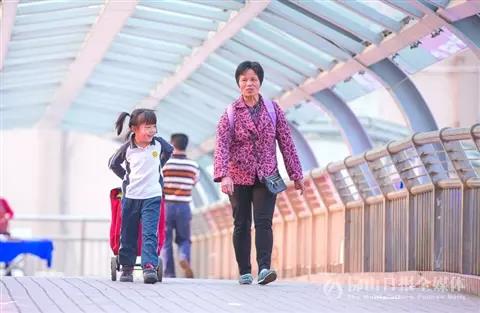 昨日气温回升,顺德陈村佛陈路天桥上,学生放学回家。 /佛山日报记者王伟楠摄