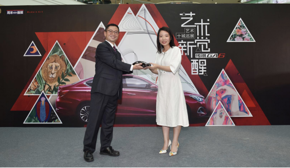 广汽传祺汽车销售有限公司市场部广告科科长常均向虞萱萱赠送纪念品