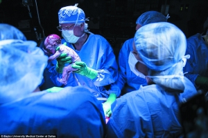 新生儿是名男婴，图为医生举着婴儿给母亲看。