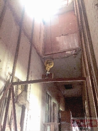 凿空楼层地板,用滑轮直接把木材拉到三楼,存在安全生产隐患。