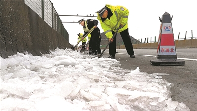 交警联合路政在清除京珠北路面的积雪。广州日报全媒体记者卜瑜 通讯员冯进富摄