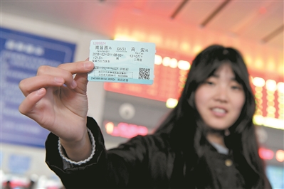 在南昌西站售票处，一位旅客展示春运首日火车票。新华社发