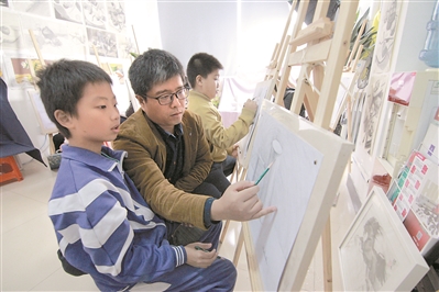 孙勇在画室内教孩子们画画。