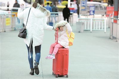 宝宝的“专车”——妈妈的行李箱。 广州日报全媒体记者葛宇飞摄