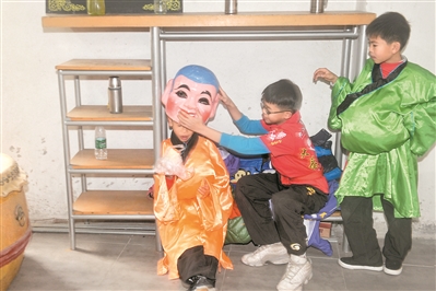 学习了一个上午的大头佛表演,小学徒在一旁休息。