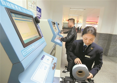 在贵州凯里火车站，工作人员在调试自动取票机。新华社发
