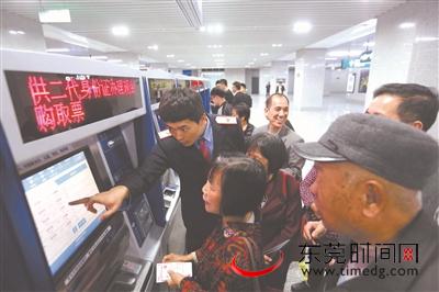 站内工作人员教市民使用自助设备购票