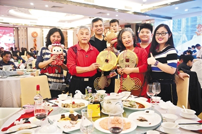 从青岛来广州旅游的高伯一家在广州酒家吃过地道的广式年夜饭后，意犹未尽，再来一个团圆照。 广州日报全媒体记者余靖、黎旭阳 摄