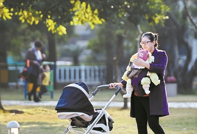 一位女士带着宝宝晒太阳。 广州日报全媒体记者石忠情摄