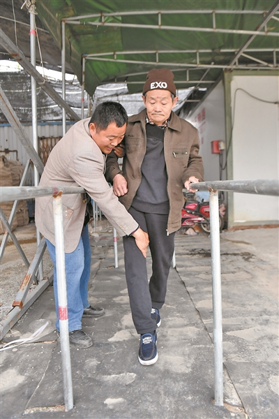 王得伟在“屋”前自制了用于康复治疗的平衡木，协助父亲训练走路。