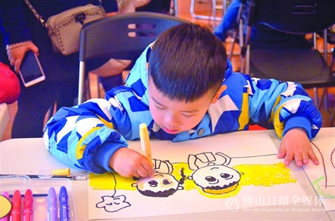 星彩世界·绘手献爱“梦想车”儿童慈善绘画大赛现场，小选手正认真作画。